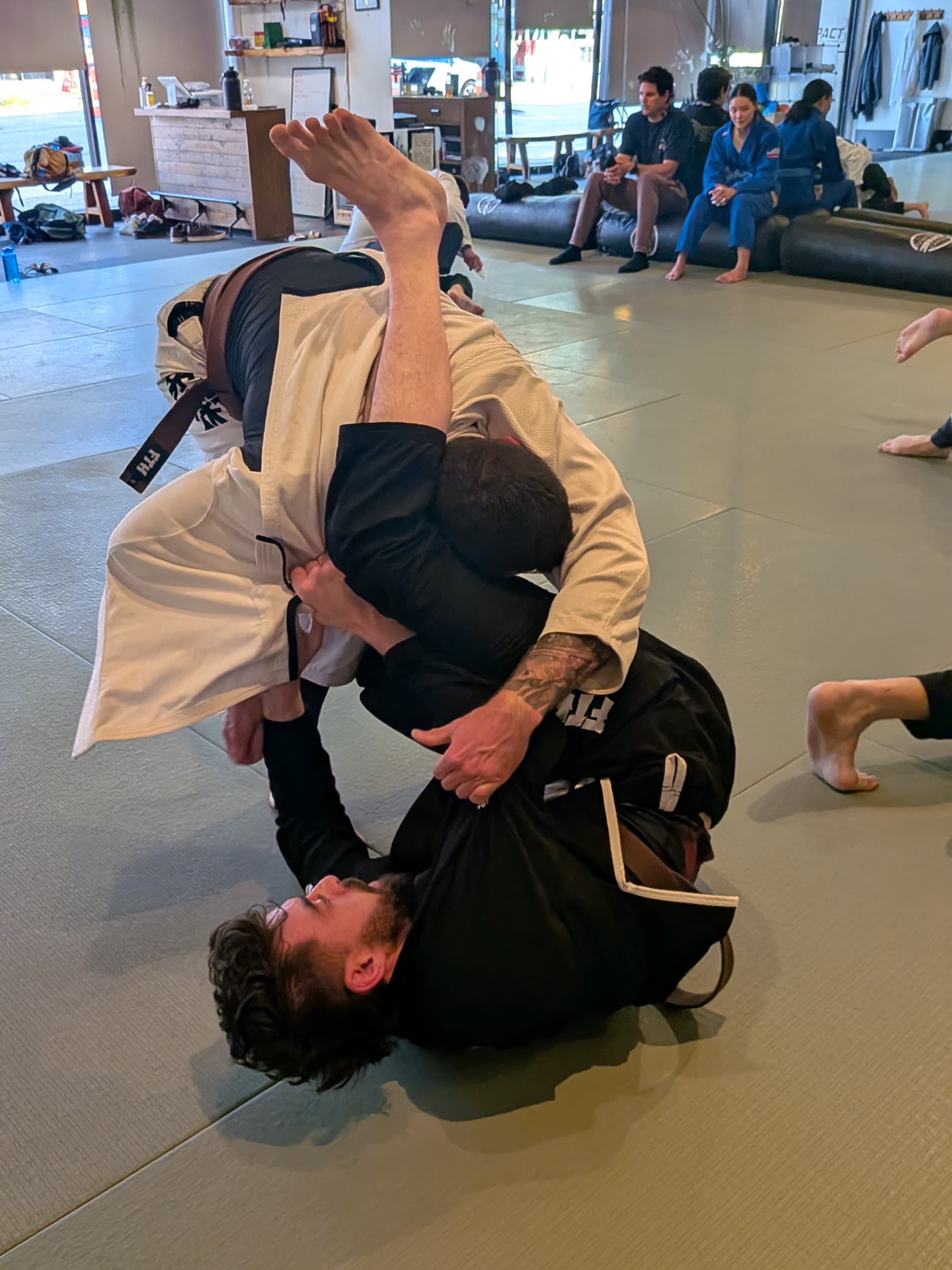 Gentle Art Collective SHINSEI Gi from From The Hills Jiu Jitsu, clean white martial arts gi with logo patches, laid flat on a surface.