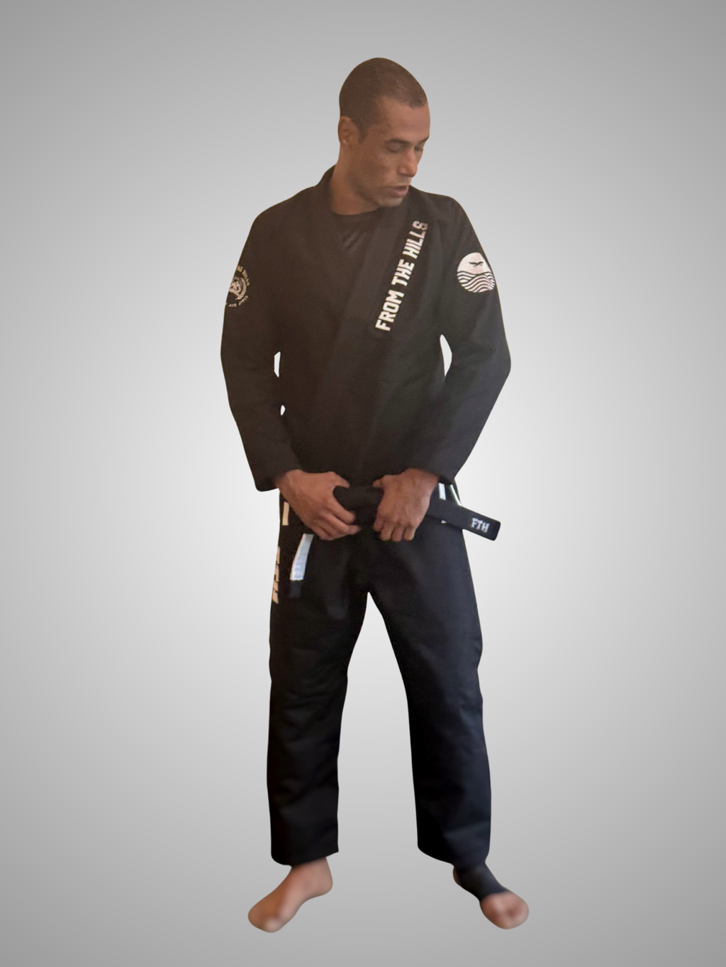 Gentle Art Collective Shinsei Gi from From The Hills Jiu Jitsu, white martial arts gi with logo patches, laid flat on a white background.